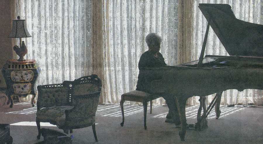 Patricia Langer playing piano in her Edina home.